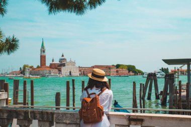 Turist kadın San Giorgio Maggiore Venedik 'e bakıyor.