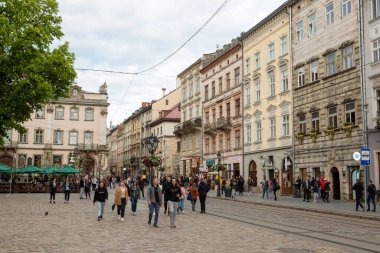 Lviv, Ukrayna - 14 Mayıs 2021: Şehir meydanında yürüyen turistler