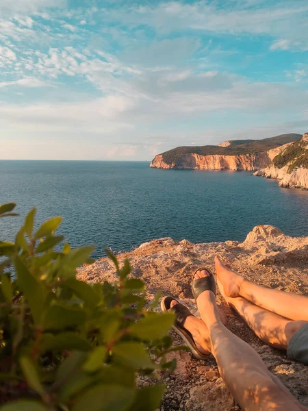 Çift Kayalıklarda Oturuyor Deniz Üzerindeki Günbatımının Keyfini Çıkarıyorlar — Stok fotoğraf