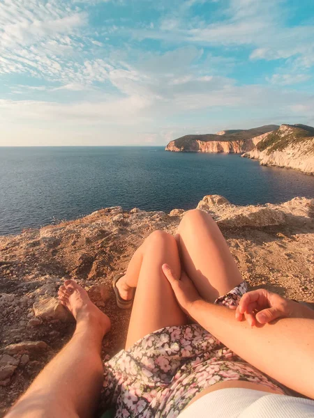 Pareja Sentada Acantilado Disfrutando Vista Del Atardecer Sobre Mar Sin —  Fotos de Stock