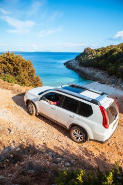 Deniz kıyısı gezisinde SUV arabalı bir adam.