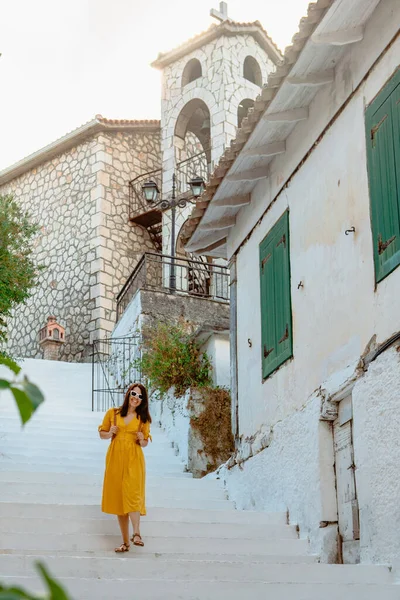旅行やアクティブなライフスタイルの概念 若いです旅行者女性で黄色のドレス歩行で古いギリシャの町 — ストック写真