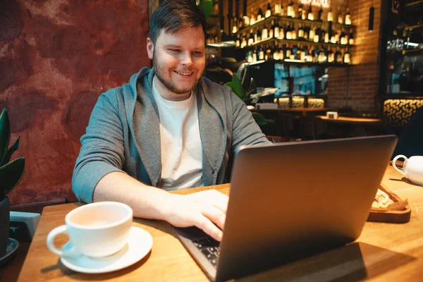 Mand Freelancer Headset Arbejder Laptop Cafe Spise Burger Drikke Kopi - Stock-foto