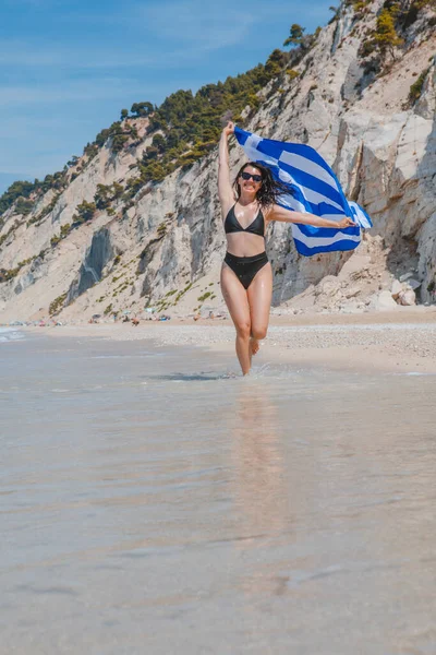 Šťastný Sexy Žena Běží Moře Pláž Řeckou Vlajkou Letní Dovolená — Stock fotografie
