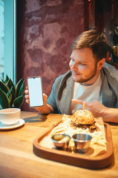 Man Cafe Holding Phone White Screen Eating Burger Drinking Tea — Stock Photo, Image