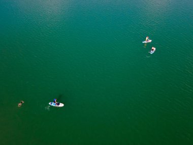 Göl fotokopi alanının ortasındaki sörf tahtalarındaki insanların genel görünümü