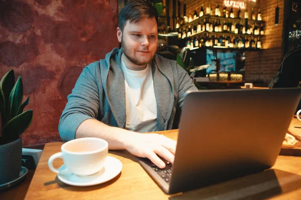 Mann Mit Headset Arbeitet Laptop Café Isst Burger Und Trinkt — Stockfoto