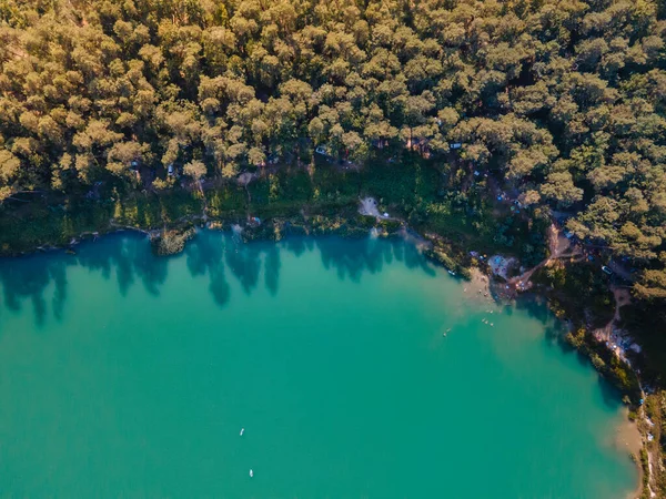 Orman fotokopi uzayındaki göl kenarındaki kamp alanının havadan görüntüsü.