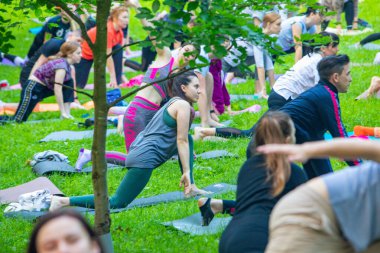 Lviv, Ukrayna - 2 Temmuz 2021: Şehir parkındaki birçok insan yoga yapıyor.
