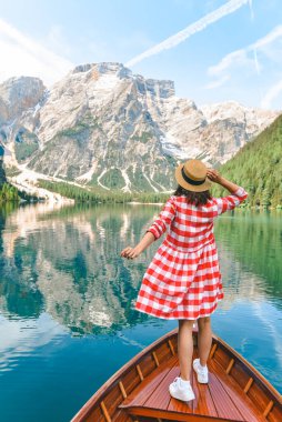İtalya 'daki lago di braies gölünde büyük kahverengi bir teknede oturan kadın. yaz tatili