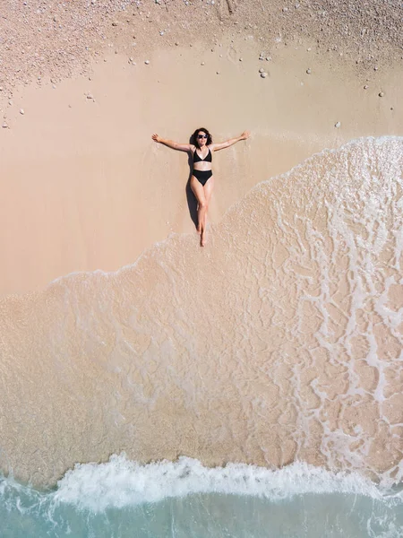 Deniz Kıyısındaki Kumsalda Güneşlenen Siyah Mayo Giymiş Bir Kadın — Stok fotoğraf