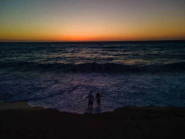 Силуэт Пары Стоящей Морском Пляже Смотрящей Сильные Волны Закате — стоковое фото