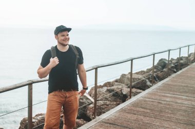 Sırt çantalı adam deniz kıyısında yürüyor Kopya alanı