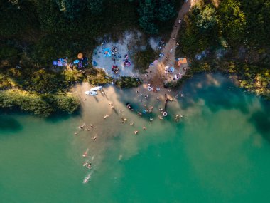 Sızdıran mavi deniz manzarası. İnsanlar yazın güneşlenirken yüzerken eğleniyorlar.