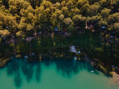 Orman fotokopi uzayındaki göl kenarındaki kamp alanının havadan görüntüsü.