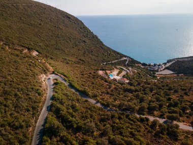 Yunanistan 'ın İyon Denizi yakınlarındaki Lefkada adasında karayoluyla hareket eden arabanın hava görüntüsü