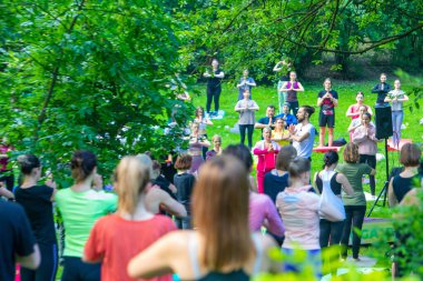 Lviv, Ukrayna - 2 Temmuz 2021: Şehir parkındaki birçok insan yoga yapıyor.