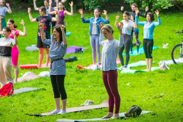 Lviv, Ukrayna - 2 Temmuz 2021: Şehir parkındaki birçok insan yoga yapıyor.