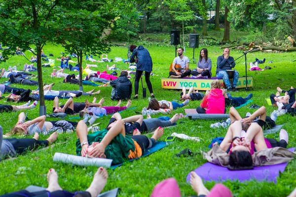 Lviv, Ukrayna - 2 Temmuz 2021: Şehir parkındaki birçok insan yoga yapıyor.