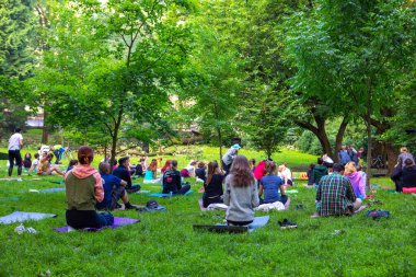Lviv, Ukrayna - 2 Temmuz 2021: Şehir parkındaki birçok insan yoga yapıyor.