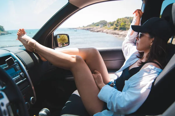 Frau sitzt im Auto zeigen sexy Beine Blick auf Sommer Meer Strand — Stockfoto