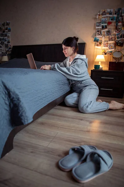 Жінка фрілансер працює вдома на ноутбуці, сидячи на підлозі — стокове фото