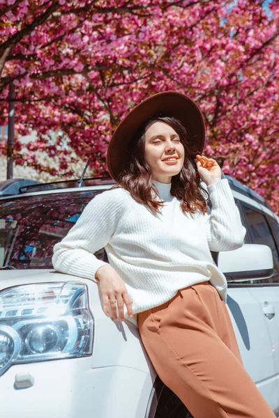 Stijlvolle Glimlach Mooie Vrouw Staan Buurt Van Auto Bloeiende Sakura — Stockfoto