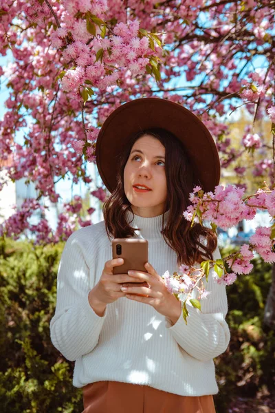 Mulher Segurando Telefone Mão Sob Florescendo Sakura Árvore Primavera Está — Fotografia de Stock