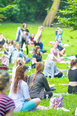 Lviv, Ukrayna - 2 Temmuz 2021: Şehir parkındaki birçok insan yoga yapıyor.