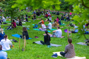 Lviv, Ukrayna - 2 Temmuz 2021: Şehir parkındaki birçok insan yoga yapıyor.