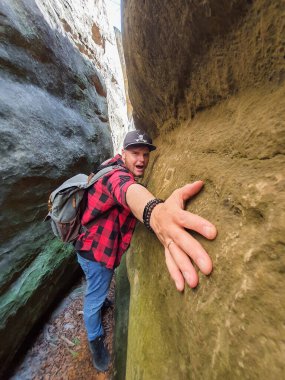 Dar kanyon kopyalama alanında sırt çantalı bir adam yürüyüşçüsü
