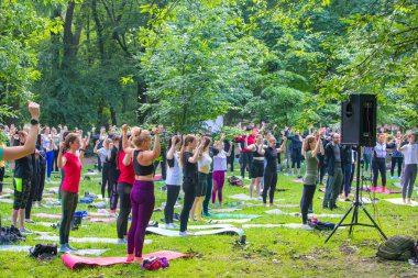 Lviv, Ukrayna - 2 Temmuz 2021: Şehir parkındaki birçok insan yoga yapıyor.