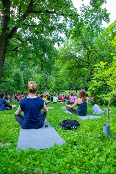 Lviv, Ukrayna - 2 Temmuz 2021: Şehir parkındaki birçok insan yoga yapıyor.
