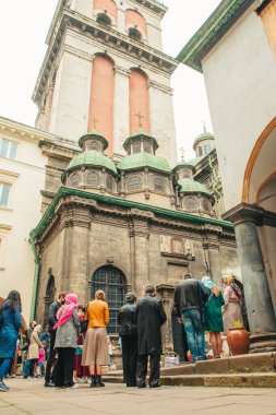 Lviv, Ukrayna - 2 Mayıs 2021: Paskalya tatili. Tapınağın yanında duran insanlar.