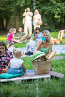 Lviv, Ukrayna - 16 Temmuz 2021: aileleri olan insanlar yaz mevsiminde şehir parkında dinleniyorlar