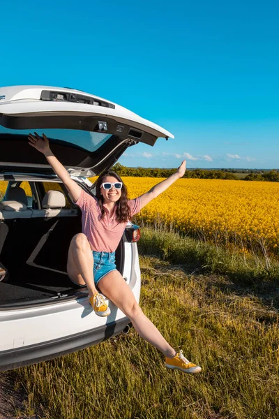 Lächelnde Hübsche Frau Sitzt Kofferraum Eines Geländewagens Bei Sonnenuntergang Und — Stockfoto