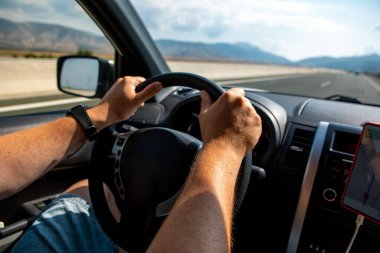 Adam ellerini direksiyona koyuyor. Araba yolculuğu konsepti yarış pisti.