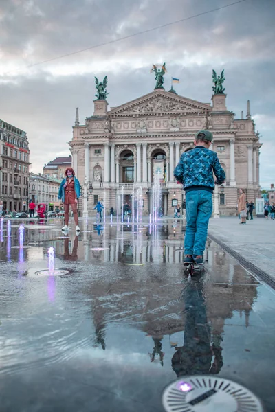 Lviv, Ukrayna - 14 Mayıs 2021: İnsanlar opera binası çeşmesinin önünde şehir meydanından yürüyorlar
