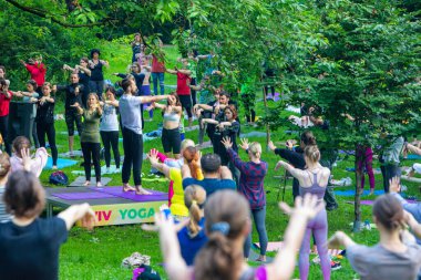 Lviv, Ukrayna - 2 Temmuz 2021: Şehir parkındaki birçok insan yoga yapıyor.