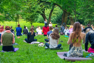 Lviv, Ukrayna - 2 Temmuz 2021: Şehir parkındaki birçok insan yoga yapıyor.