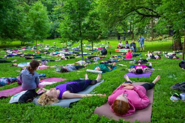 Lviv, Ukrayna - 2 Temmuz 2021: Şehir parkındaki birçok insan yoga yapıyor.