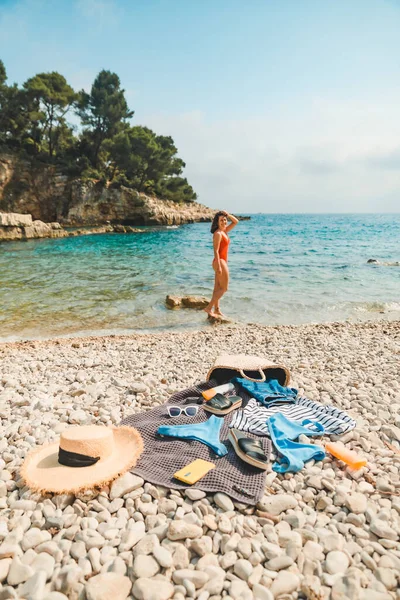 年轻性感女子穿着红色泳衣在海滩的东西在毛毯暑假 — 图库照片