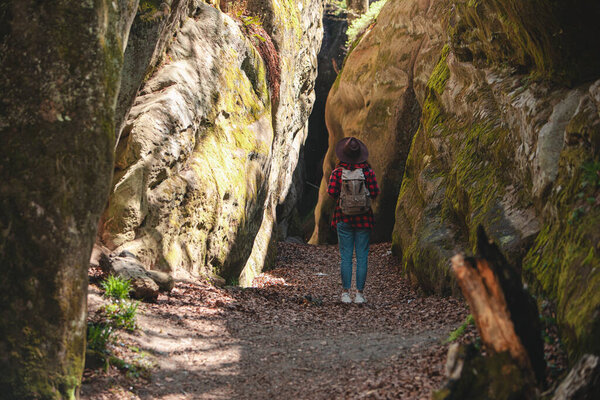 woman hiker with backpack walking by trail in canyon