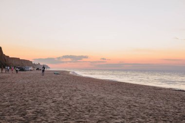 Kumlu deniz sahilinin üzerinde gün doğumunun manzarası. Boşluğu kopyala