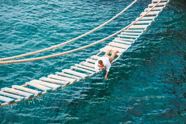 Homem Deitado Ponte Suspensa Desfrutando Vista Para Mar Natureza Calma — Fotografia de Stock