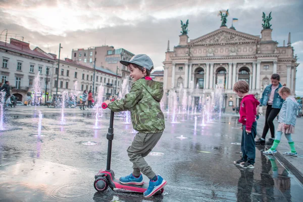 Lviv, Ukrayna - 14 Mayıs 2021: İnsanlar opera binası çeşmesinin önünde şehir meydanından yürüyorlar