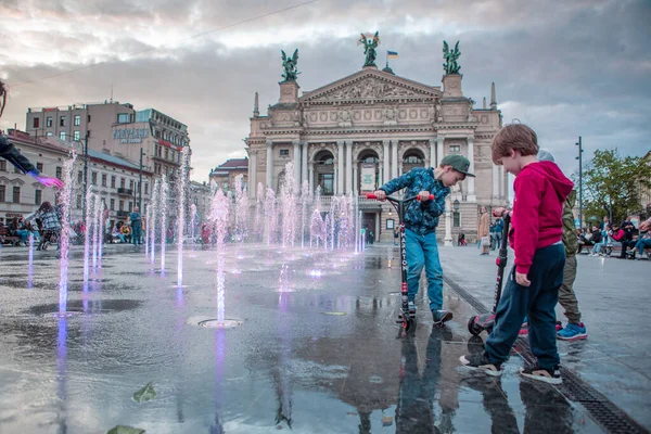Lviv, Ukrayna - 14 Mayıs 2021: İnsanlar opera binası çeşmesinin önünde şehir meydanından yürüyorlar