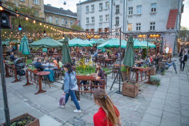 Lviv, Ukraine - May 14, 2021: people at outdoors street cafe flexing talking relaxing clipart