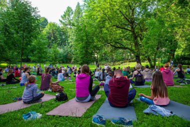 Lviv, Ukrayna - 2 Temmuz 2021: Şehir parkındaki birçok insan yoga yapıyor.