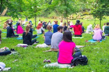 Lviv, Ukrayna - 2 Temmuz 2021: Şehir parkındaki birçok insan yoga yapıyor.